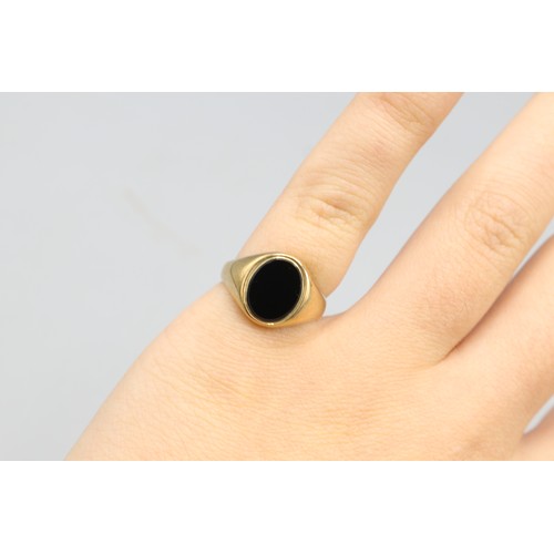 31 - Hallmarked 9ct yellow gold onyx signet ring, comprising a 10 × 7.5mm oval onyx set within a plain ta... 