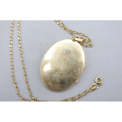 51 - Large hallmarked 9ct yellow gold oval hinged locket with scrollwork-engraved front and fluted bail, ... 
