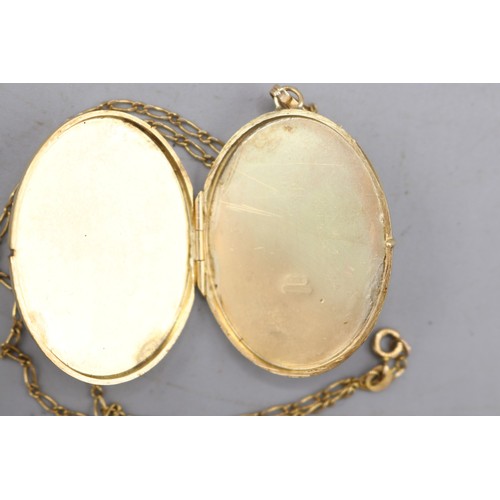 51 - Large hallmarked 9ct yellow gold oval hinged locket with scrollwork-engraved front and fluted bail, ... 