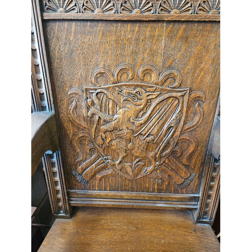 21 - Ornately carved oak Wainscot carvery chair. Carved with dragon in shield.