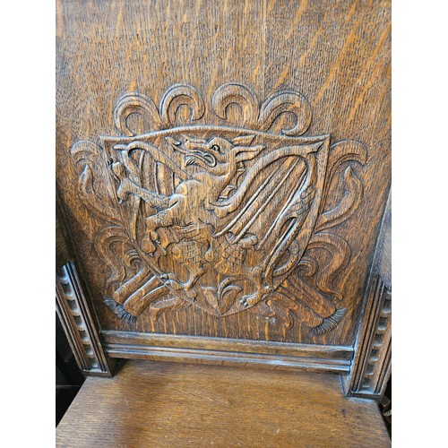 21 - Ornately carved oak Wainscot carvery chair. Carved with dragon in shield.