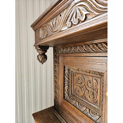 22 - Antique deeply carved oak court cupboard. Splits in two pieces.