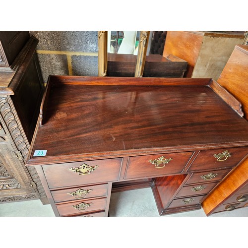 23 - Antique flame mahogany kneehole desk. Drop brass handles and gallery