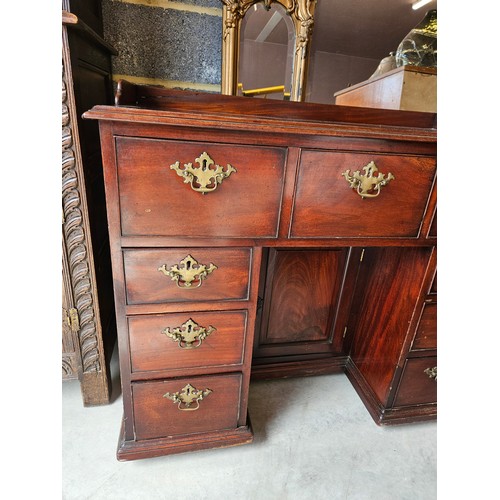 23 - Antique flame mahogany kneehole desk. Drop brass handles and gallery