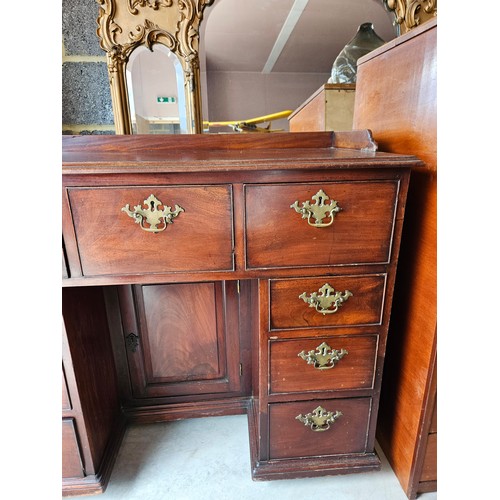 23 - Antique flame mahogany kneehole desk. Drop brass handles and gallery