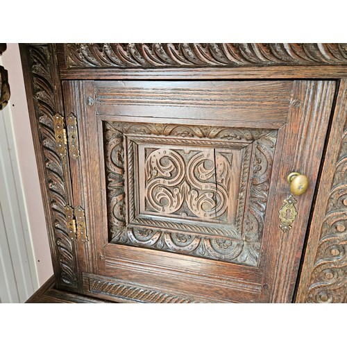 22 - Antique deeply carved oak court cupboard. Splits in two pieces.