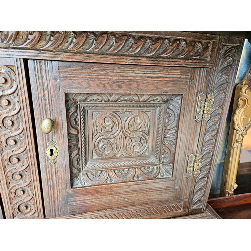 22 - Antique deeply carved oak court cupboard. Splits in two pieces.