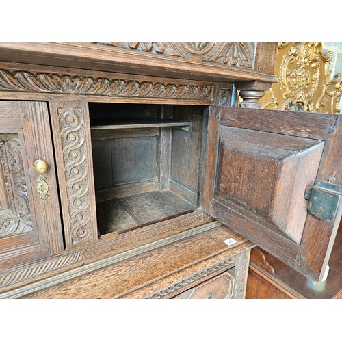 22 - Antique deeply carved oak court cupboard. Splits in two pieces.