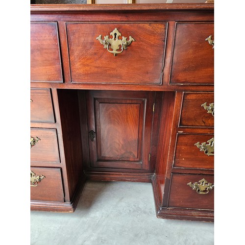 23 - Antique flame mahogany kneehole desk. Drop brass handles and gallery