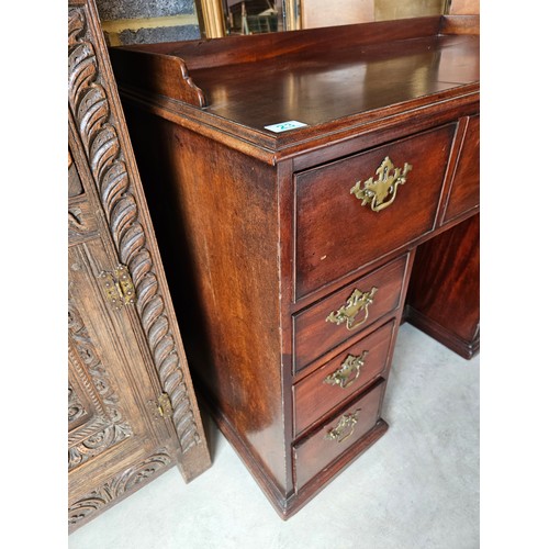 23 - Antique flame mahogany kneehole desk. Drop brass handles and gallery