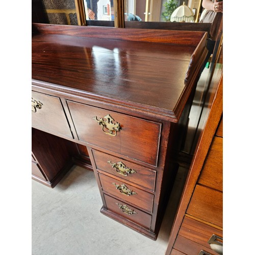 23 - Antique flame mahogany kneehole desk. Drop brass handles and gallery