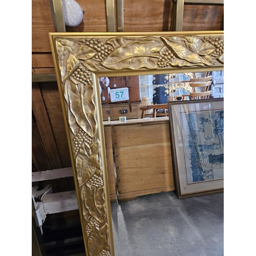 57 - Gold guilt and beveled edge mirror. With leaf decoration