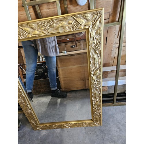 57 - Gold guilt and beveled edge mirror. With leaf decoration