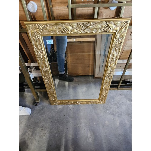 57 - Gold guilt and beveled edge mirror. With leaf decoration