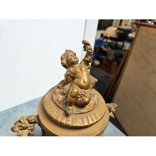 305 - Highly ornate cast & gilt metal urn with lift off lid and cherubs