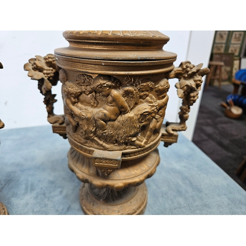 305 - Highly ornate cast & gilt metal urn with lift off lid and cherubs