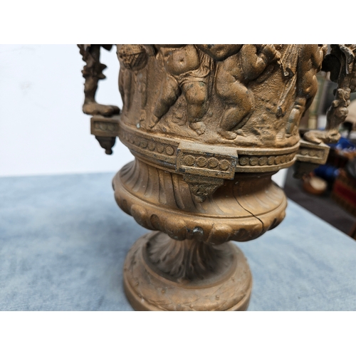 305 - Highly ornate cast & gilt metal urn with lift off lid and cherubs