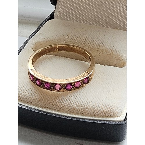 580D - 9ct yellow gold.
Ruby and diamond half eternity ring.
3.19g