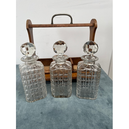 175 - Antique oak tantalus with three crystal decanters