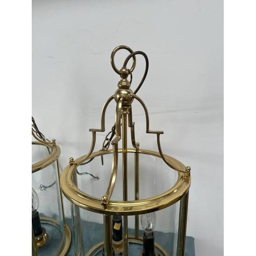 187 - Large pair of brass lantern ceiling lights. Shade is constructed of one piece of glass.