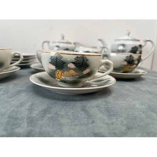 323 - Oriental Japanese bone China porcelain tea set. The cups feature geisha girls in the bases.