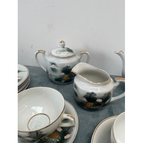 323 - Oriental Japanese bone China porcelain tea set. The cups feature geisha girls in the bases.