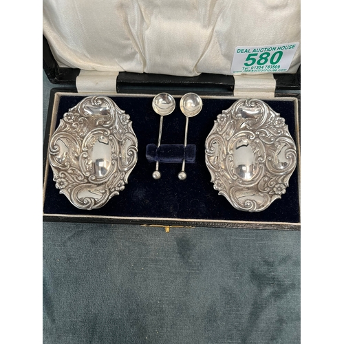 580 - Pair of white metal salts with spoons. In leather case