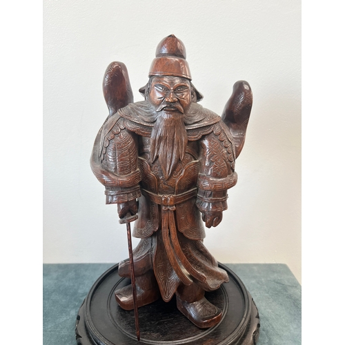 160 - Chinese carved hardwood model of a warrior. On a hardwood stand