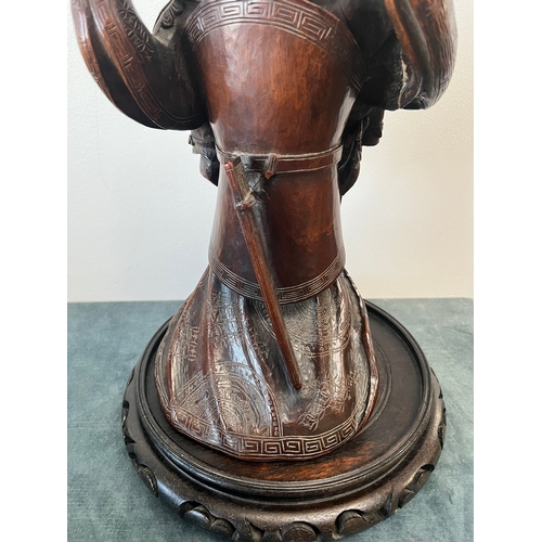 160 - Chinese carved hardwood model of a warrior. On a hardwood stand