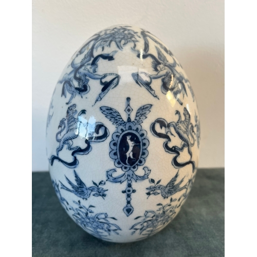 202 - Vintage blue and white egg decorated with cherubs and crests.