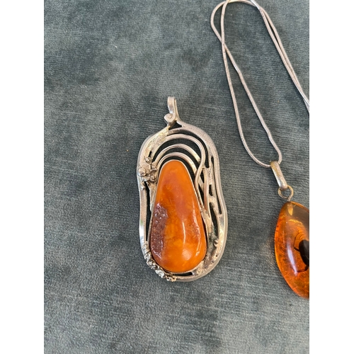 512 - Amber pendant with an internal bug on a silver chain and a silver and natural amber necklace pendant... 