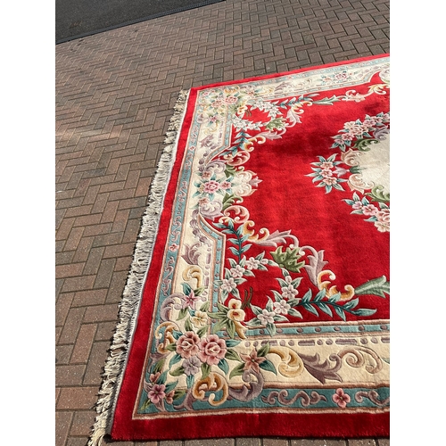 79 - Large red oriental style wool rug 

275cm x 370cm