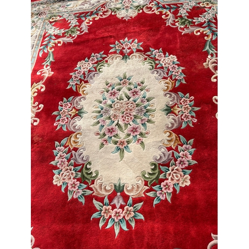 79 - Large red oriental style wool rug 

275cm x 370cm