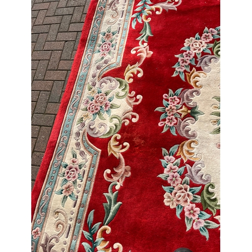 79 - Large red oriental style wool rug 

275cm x 370cm