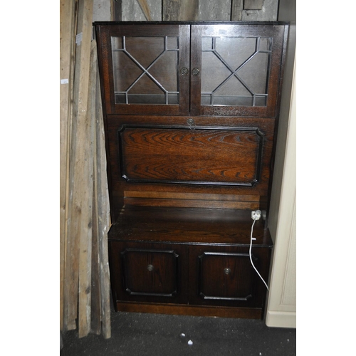 972 - A DARK OAK PART GLAZED CABINET, 2 DOORS OVER A FOLD DOWN FULL WIDTH DOOR OVER A FURTHER 2 DOORS IN T... 