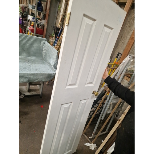 64 - A Four-Panel Painted Timber Interior Door with Brass-Finish FittingsA traditional style interior d... 