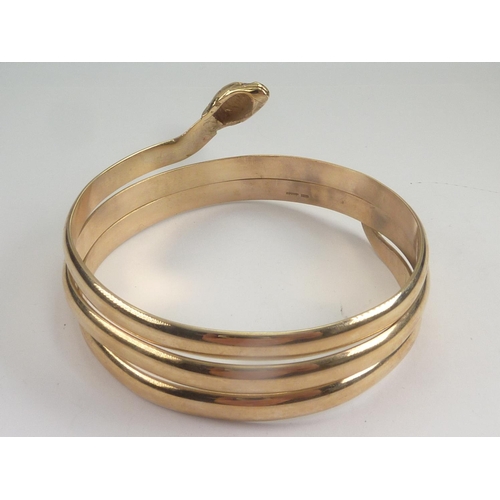 70 - 9ct gold bangle modelled as a serpent with three plain coils and ruby eyes.