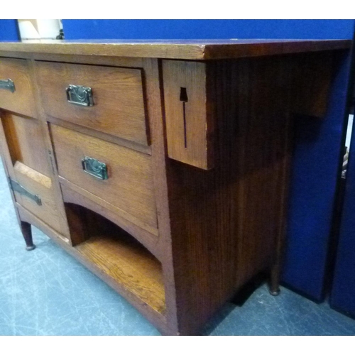 617 - Edwardian oak Arts and Crafts sideboard, the central cupboard flanked by two small drawers over rece... 