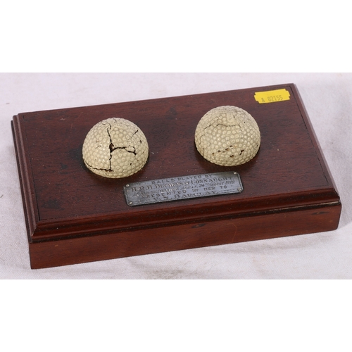 235 - Two early Martins Zodiac golf balls with propeller marks raised on mahogany stand with plaque readin... 