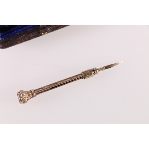 92 - Unhallmarked yellow metal propelling awl or manicure item with amethyst finial, 6cm long