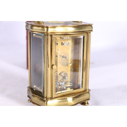 217 - French carriage clock in serpentine case with further leather carrying case, 16cm tall