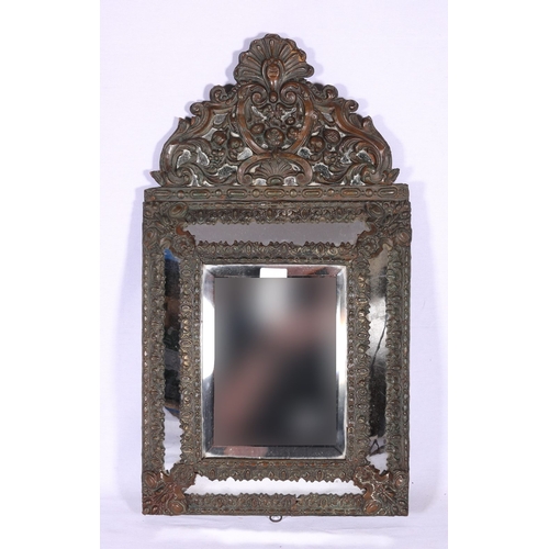 188 - Wall mirror with bevelled glass of cushioned shape decorated with C scrolls and foliage, 60cm tall