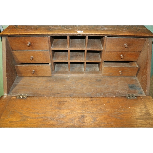 471 - Jacobean revival carved oak bureau with arrangement of five drawers having mask handles, 93cm wide