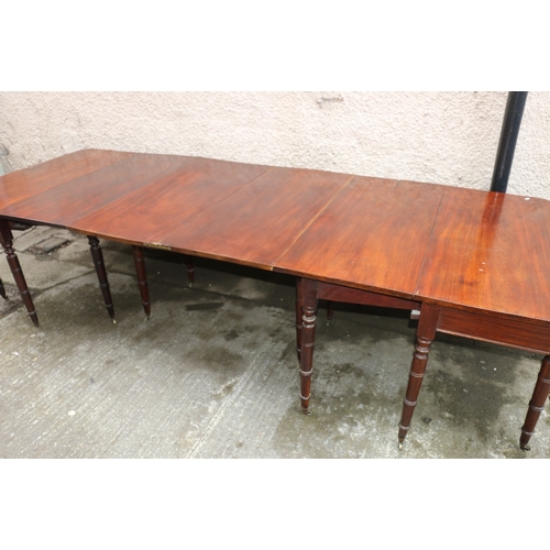 477 - Early 19th century mahogany dining table raised on turned supports capped by casters, approximately ... 