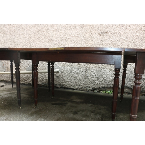 477 - Early 19th century mahogany dining table raised on turned supports capped by casters, approximately ... 