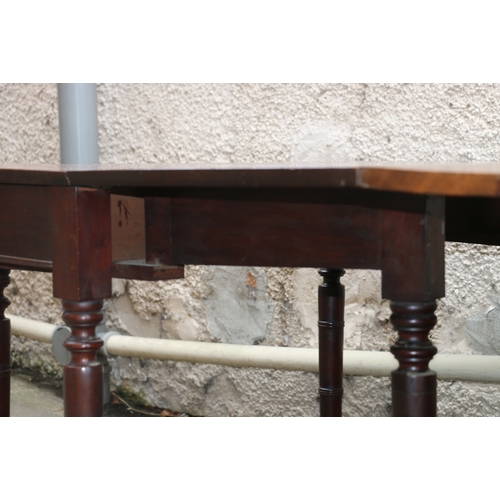 477 - Early 19th century mahogany dining table raised on turned supports capped by casters, approximately ... 