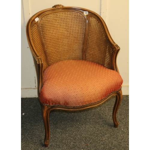 486 - French style bergere tub chair with carved top rail, raised on cabriole supports, 87cm tall.