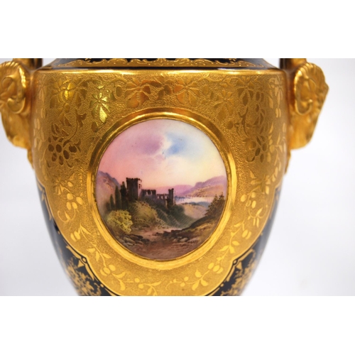 197 - Coalport urn and cover with blue glaze overlaid with gilt highlights and a panel depicting a ruin, w... 