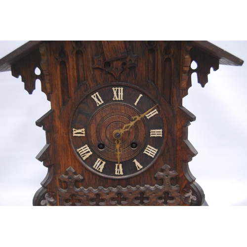 222 - Black Forest cuckoo clock with fretwork pediment over turned face, Roman numerals, flanked by carved... 