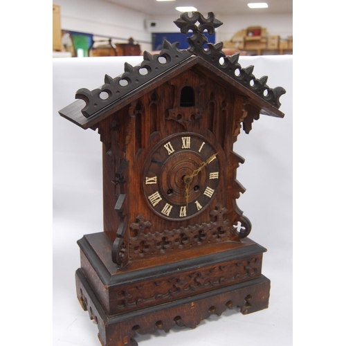 222 - Black Forest cuckoo clock with fretwork pediment over turned face, Roman numerals, flanked by carved... 